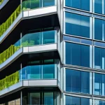 소방설비기사의 주요 연구 주제 - A futuristic, sustainable high-rise building in a bustling Spanish city, featuring a sleek glass and...